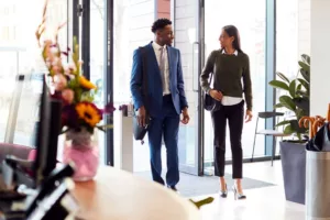 man and woman walking into office